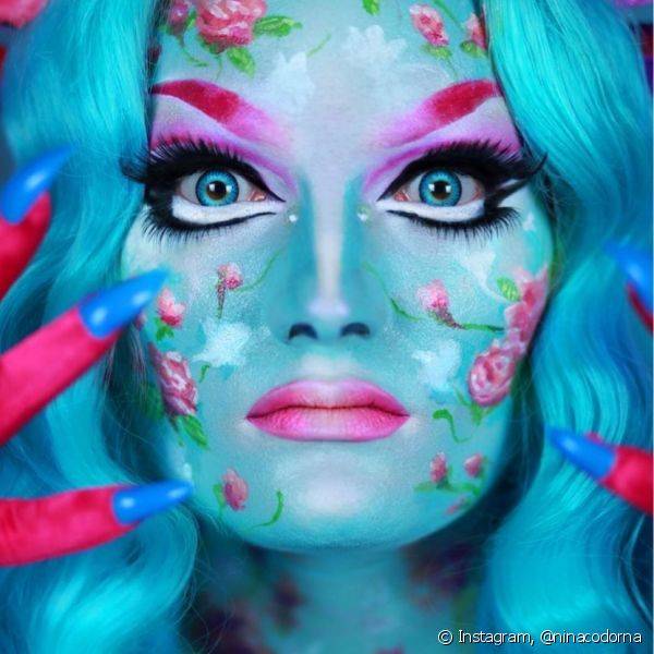 O look contou com pele azul e padrão florido, olhos dramáticos e sobrancelhas e boca ombré rosa (Foto: Instagram @ninacodorna)